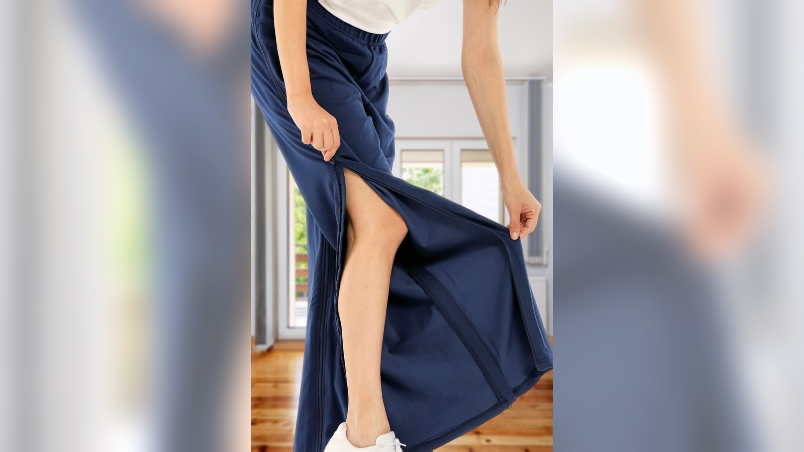 Frau in der Pflegehose mit Reißverschluss in Navy, das Hosenbein ist seitlich geöffnet