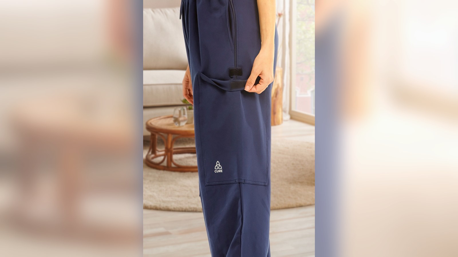 Pflegehose in Navy von der Seite, die Beintasche am Oberschenkel ist geschlossen, von außen eine normale Hose
