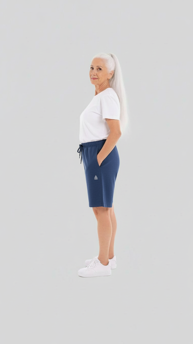 ComfortCure Adaptive Pflegeshorts für bettlägerige Patienten - mit Druckknöpfen, Navy, Seitenansicht mit geschlossenen Shorts, Hand in der Tasche