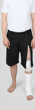 ComfortCure Adaptive Pflegeshorts für bettlägerige Patienten - Klettverschluss, vorne komplett zu öffnen, Schwarz, Vorderansicht, Beinöffnung über Knieverband und Gips