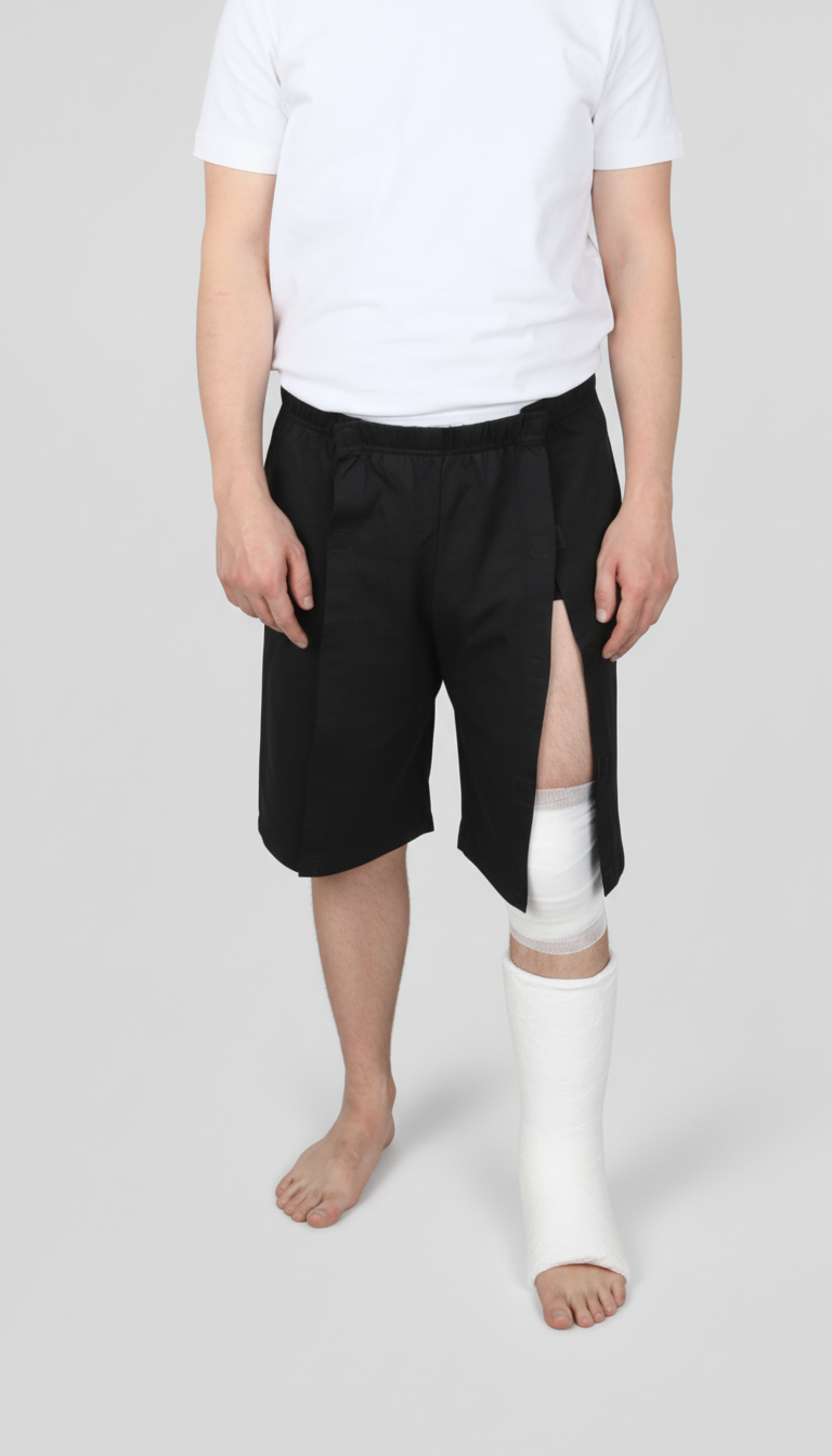 ComfortCure Adaptive Pflegeshorts für bettlägerige Patienten - Klettverschluss, vorne komplett zu öffnen, Schwarz, Vorderansicht, Beinöffnung über Knieverband und Gips