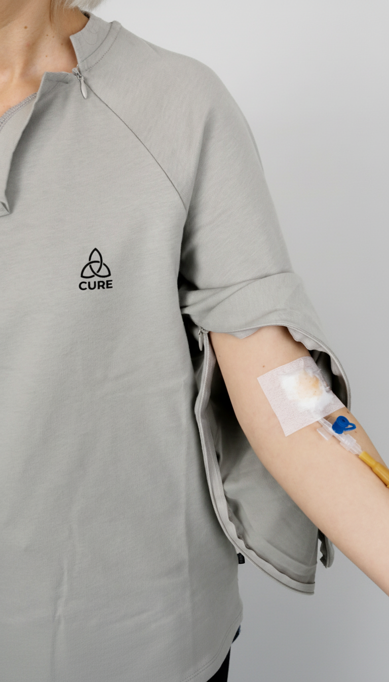 ComfortCure Adaptives Pflegeoberteil mit Port- und Dialysezugang, Grau meliert, Detailansicht, Ärmelreißverschluss geöffnet mit Infusionszugang
