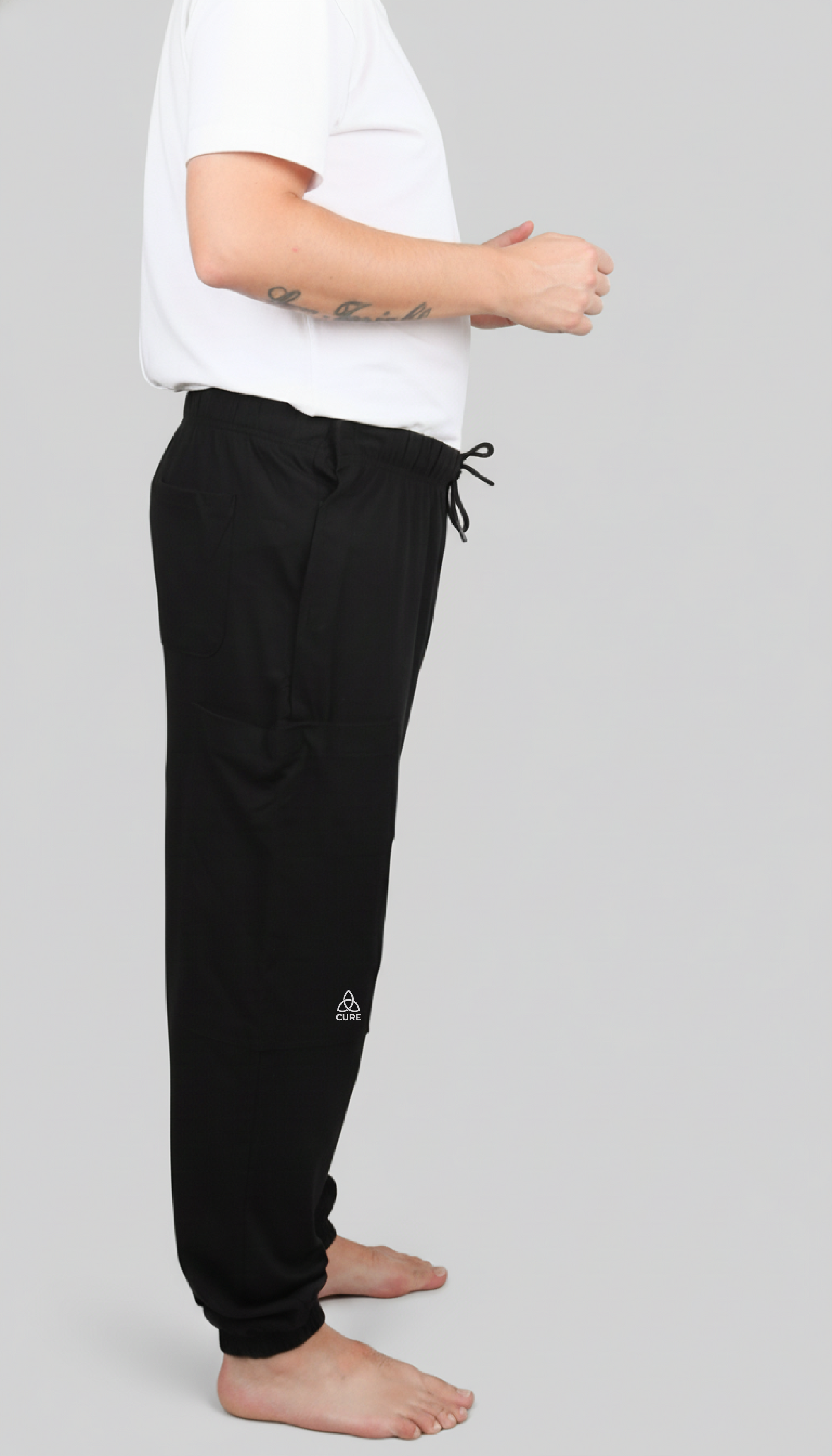 ComfortCure Adaptive Pflegehose für Prostatapatienten (mit Beintaschen), Schwarz, Seitenansicht mit Beintasche, CURE-Logo und hinterer Tasche