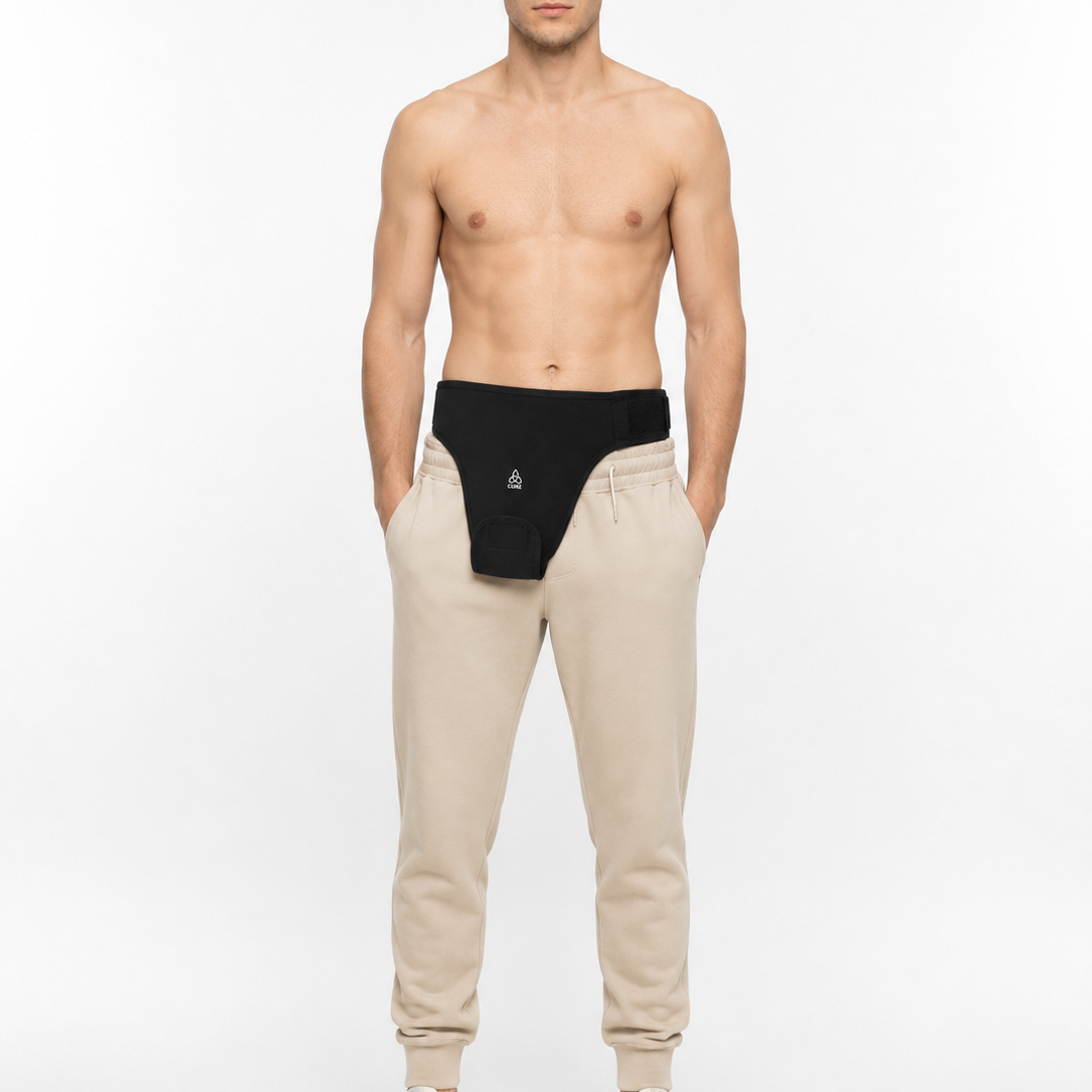 ComfortCURE StomaSecure™ Ostomie-Stützgürtel, Schwarz, Vorderansicht am barhäutigen Modell über beiger Jogginghose