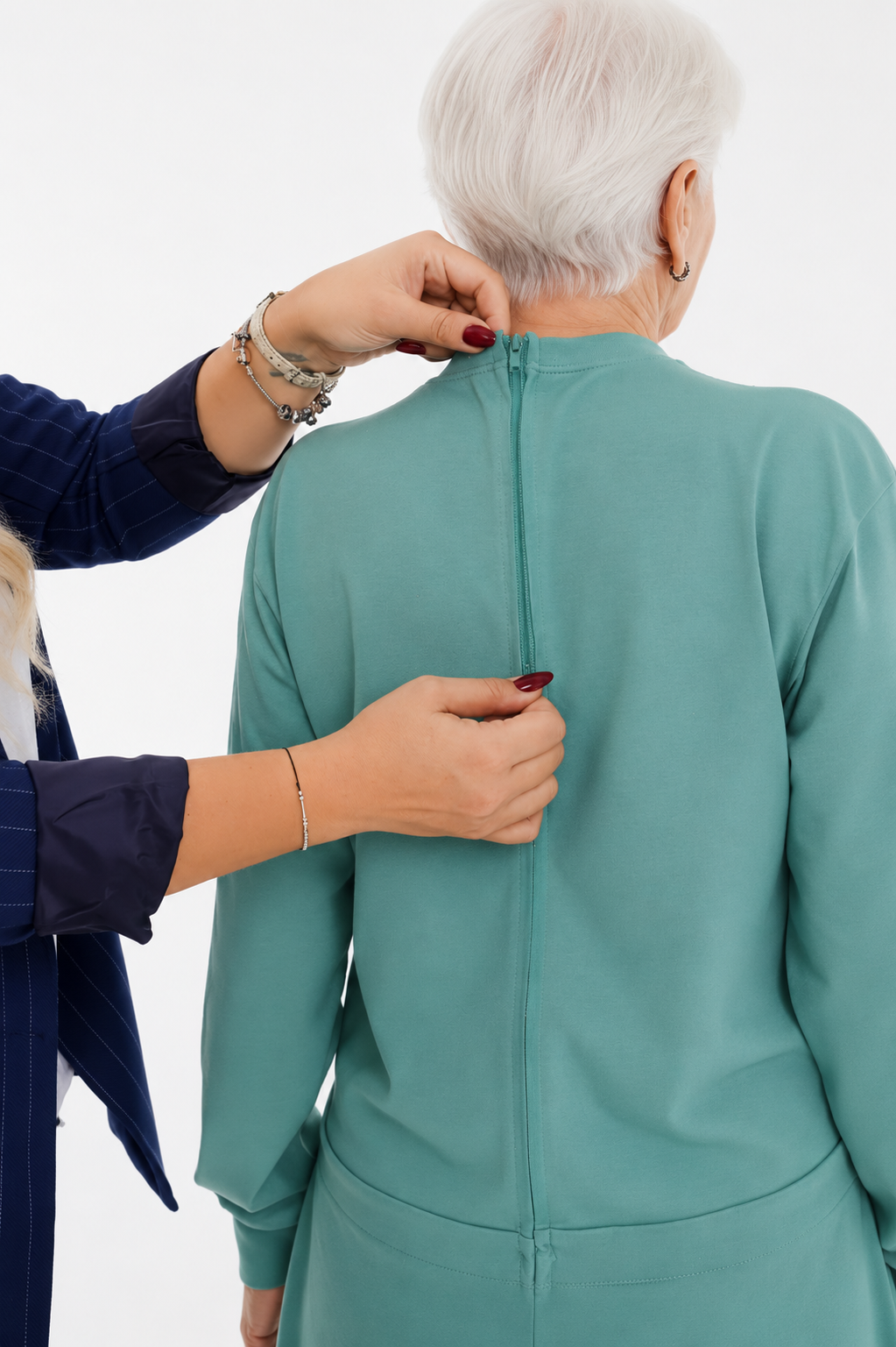 ComfortCure Adaptiver Pflegeoverall für die Alzheimer- und Demenzpflege, Grün, Rückansicht, Pflegeperson schließt den Rückenreißverschluss