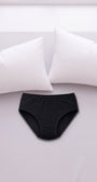 ComfortCure Adaptiver auslaufsicherer Damenslip, Schwarz, auf einem hellen Bett liegend