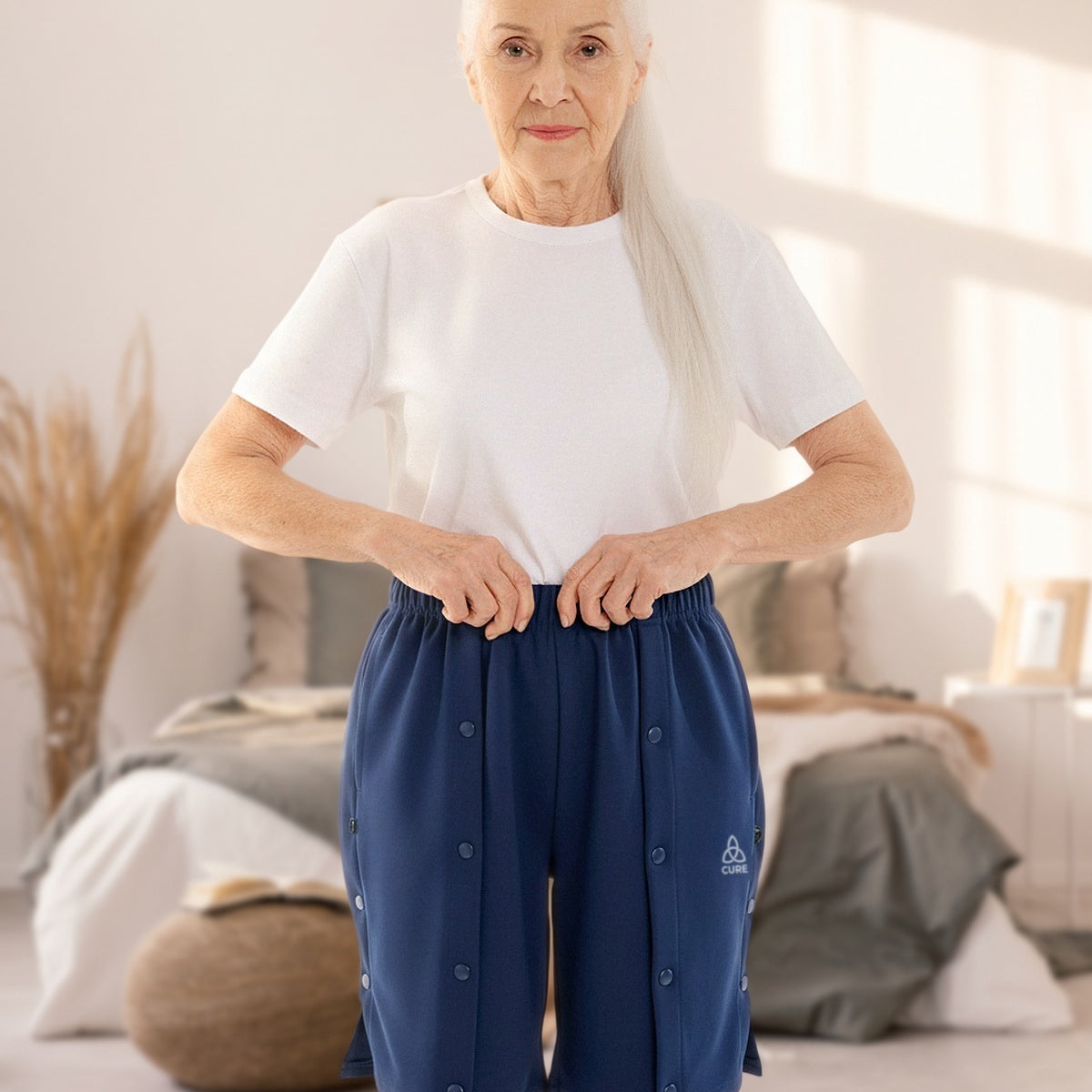 ComfortCure Adaptive Pflegeshorts für bettlägerige Patienten mit Druckknöpfen, Navy, Vorderansicht im Schlafzimmer