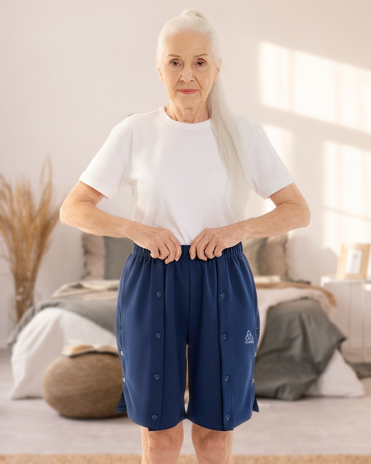 ComfortCure Adaptive Pflegeshorts für bettlägerige Patienten mit Druckknöpfen, Navy, Vorderansicht im Schlafzimmer