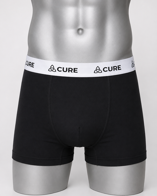 ComfortCure Alltags-Set, drei auslaufsichere Herren-Boxershorts in Schwarz, Vorderansicht auf Torso mit weißem Markenbund