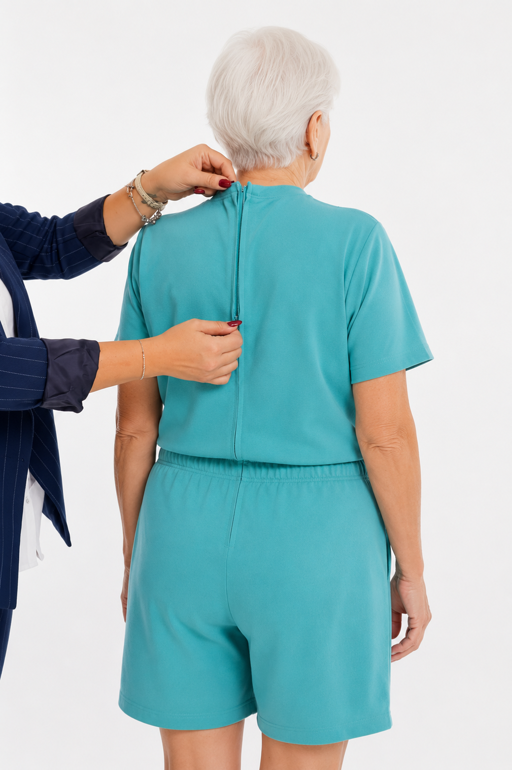 ComfortCure Adaptiver Kurzarm-Pflegeoverall für die Alzheimer- und Demenzpflege, Grün, Rückansicht, Pflegeperson öffnet den Rückenreißverschluss