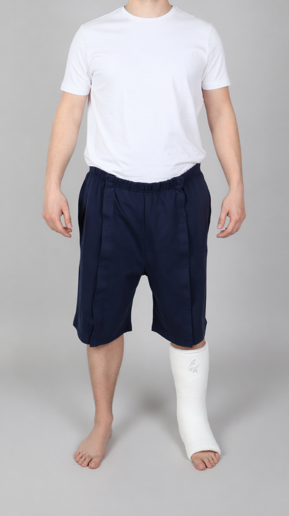 ComfortCure Adaptive Pflegeshorts für bettlägerige Patienten - Klettverschluss, vorne komplett zu öffnen, Navy, Vorderansicht geschlossen mit Gips am linken Unterschenkel