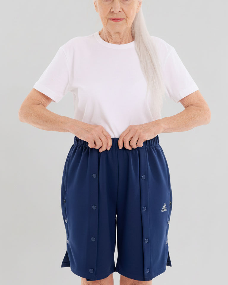 ComfortCure Adaptive Pflegeshorts für bettlägerige Patienten - mit Druckknöpfen, Navy, Vorderansicht mit geschlossenen Druckknöpfen, Hände am Bund