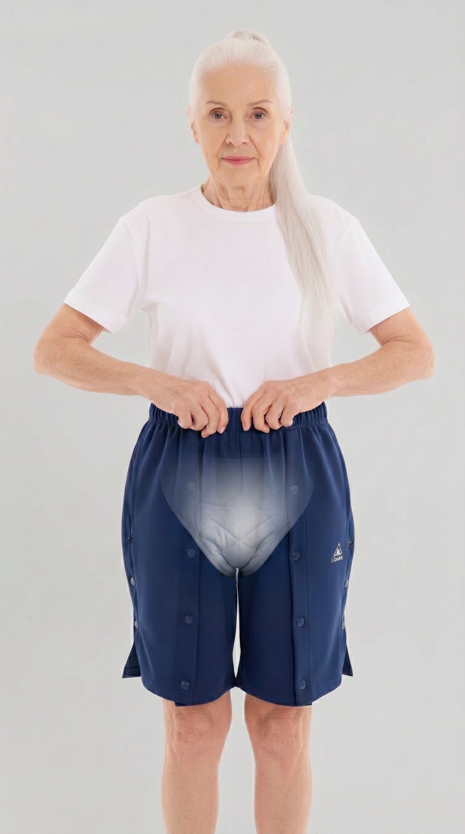 ComfortCure Adaptive Pflegeshorts für bettlägerige Patienten - mit Druckknöpfen, Navy, Vorderansicht mit transparenter Einblendung der Inkontinenzvorlage, Hände am Bund