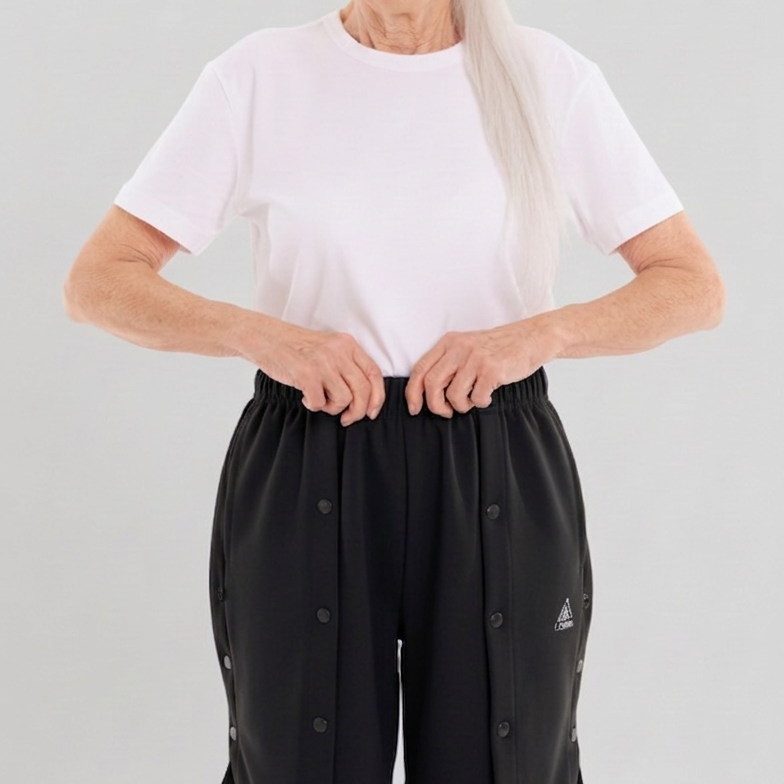 ComfortCure Adaptive Pflegeshorts für bettlägerige Patienten - mit Druckknöpfen, Grau meliert, Vorderansicht mit geschlossenen Druckknöpfen, Hände am Bund