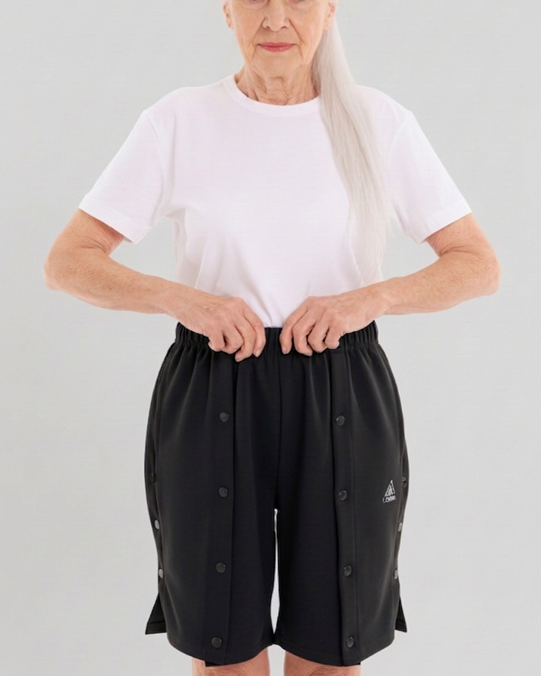 ComfortCure Adaptive Pflegeshorts für bettlägerige Patienten - mit Druckknöpfen, Grau meliert, Vorderansicht mit geschlossenen Druckknöpfen, Hände am Bund