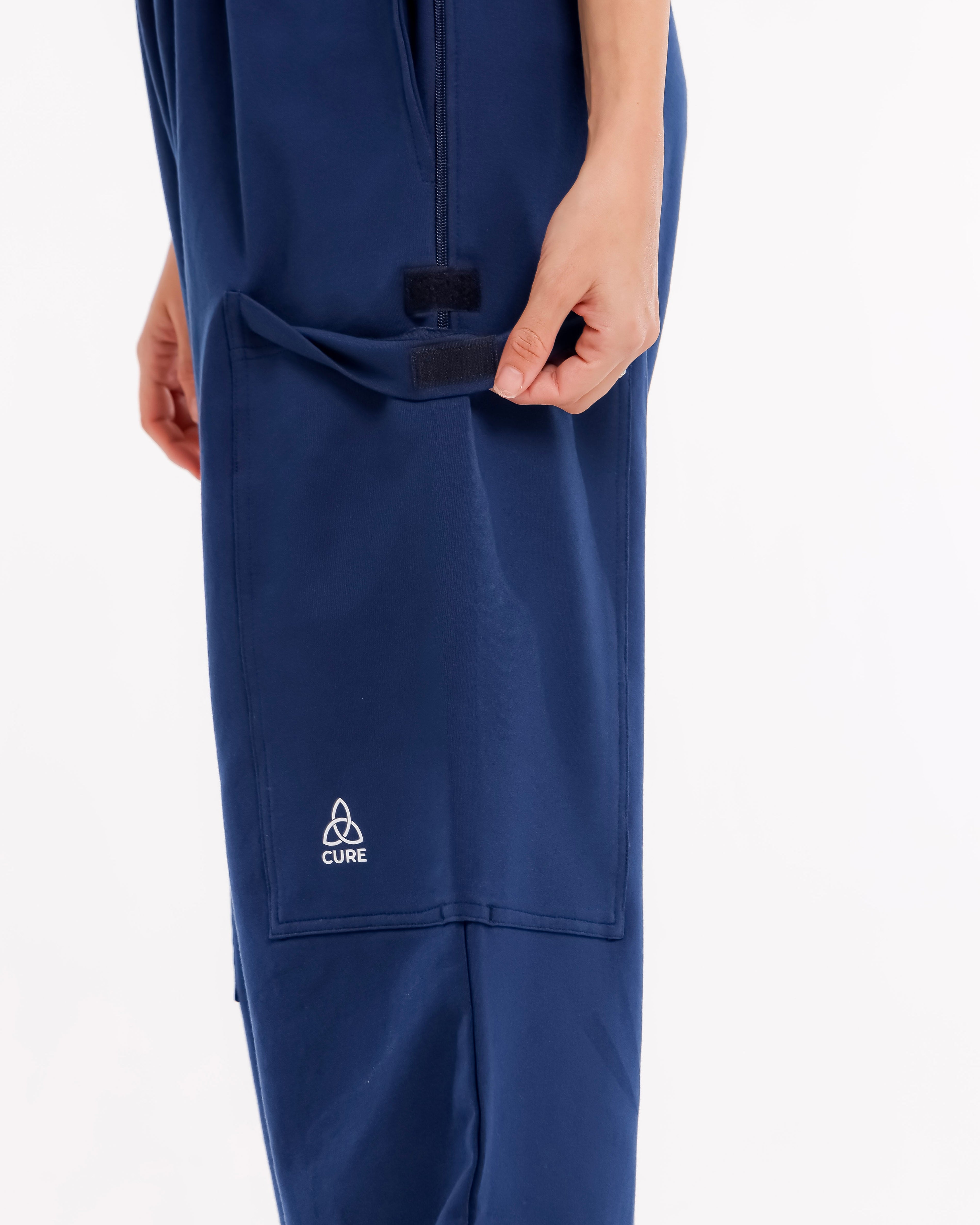 ComfortCure Adaptive Pflegehose für Prostatapatienten (mit Beintaschen), Navy, Detailansicht, Hand öffnet Klettklappe der Beintasche